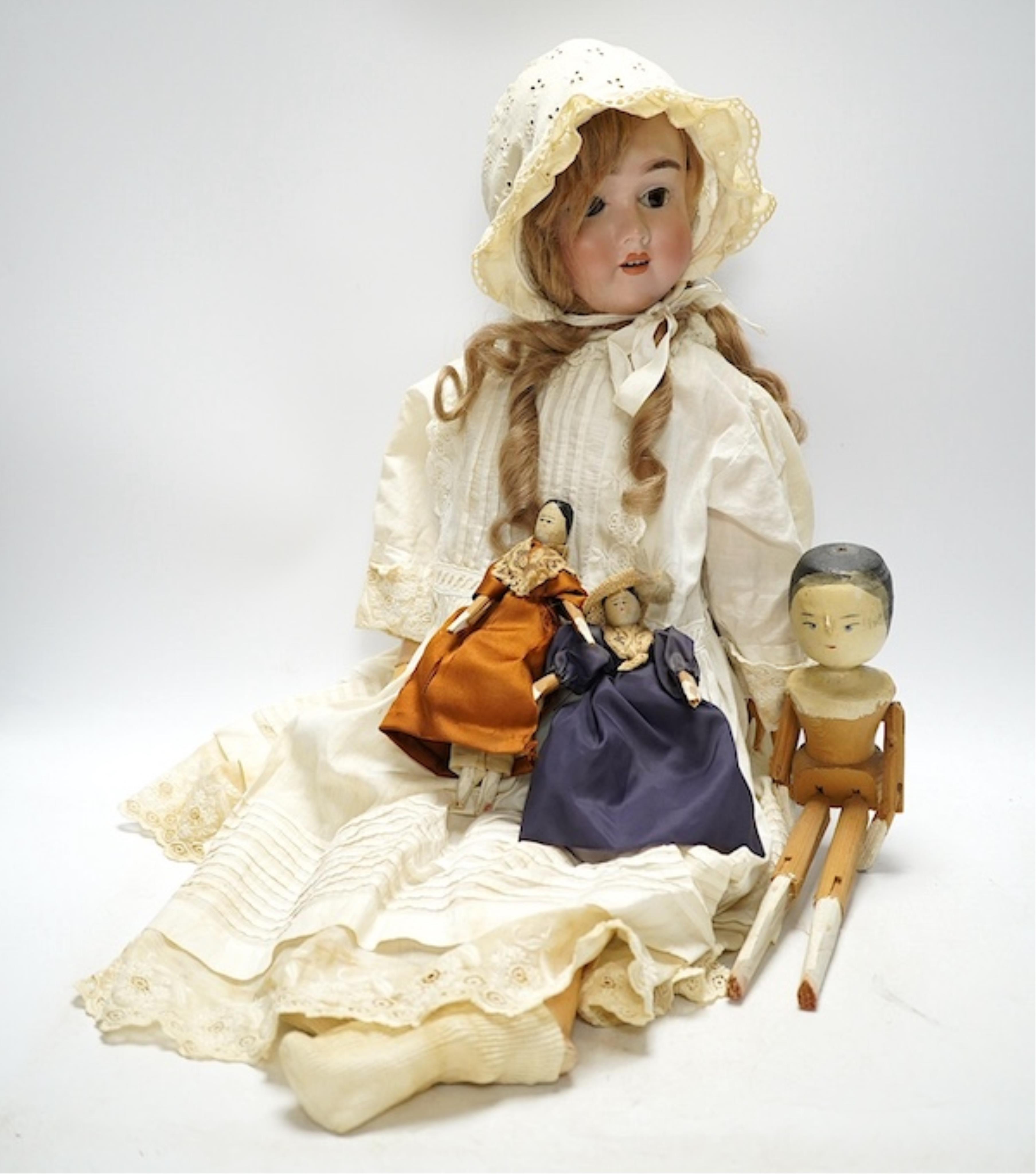 A Max Handwerck doll, jointed body, vintage clothes, 60cm high, one finger broken, together with a collection of eleven peg wooden dolls, 10cm to 30.5cm high, together with modern fashion plates (13). Condition - fair